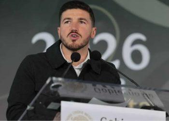 Man Speaking at a Podium with Two Microphones During a Formal Event, Blurred Backdrop Showing 2026 Behind Him. | La Silla Regia