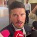 Samuel-garcia-ordena-vetar-a-medio-el-norte | La Silla Regia Man in a Dark Suit Speaking to Reporters, Microphones Pressed Close in a Hallway Interview Setting. | La Silla Regia
