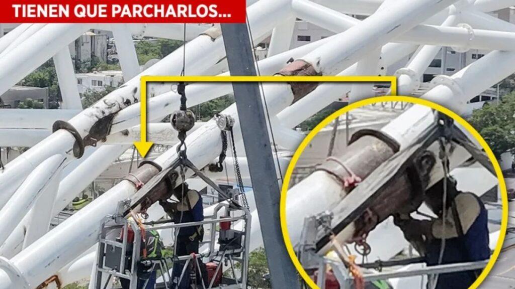 Two Workers on a Suspended Platform Repair a White Steel Structure, with Safety Ropes and Tools Visible. a Yellow Highlight Marks the Repair Area on a Pipe Stacked Across Beams. | La Silla Regia
