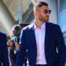 Bloque 2- Julio 5 | La Silla Regia Two Men in Navy Suits Walk Outside a Glass-fronted Building, One Wearing Sunglasses While a Photographer/crew Follows with a Microphone Boom Nearby. | La Silla Regia