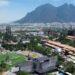 Aerial View of a City with a Large Sports Field, Festival Grounds, and Industrial Structures, Set Against a Mountain Backdrop. | La Silla Regia