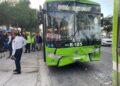 Front View of a Bright Green Bus with a Cracked Windshield and Dented Bumper After a Collision, with Emergency Responders and Bystanders on the Sidewalk | La Silla Regia